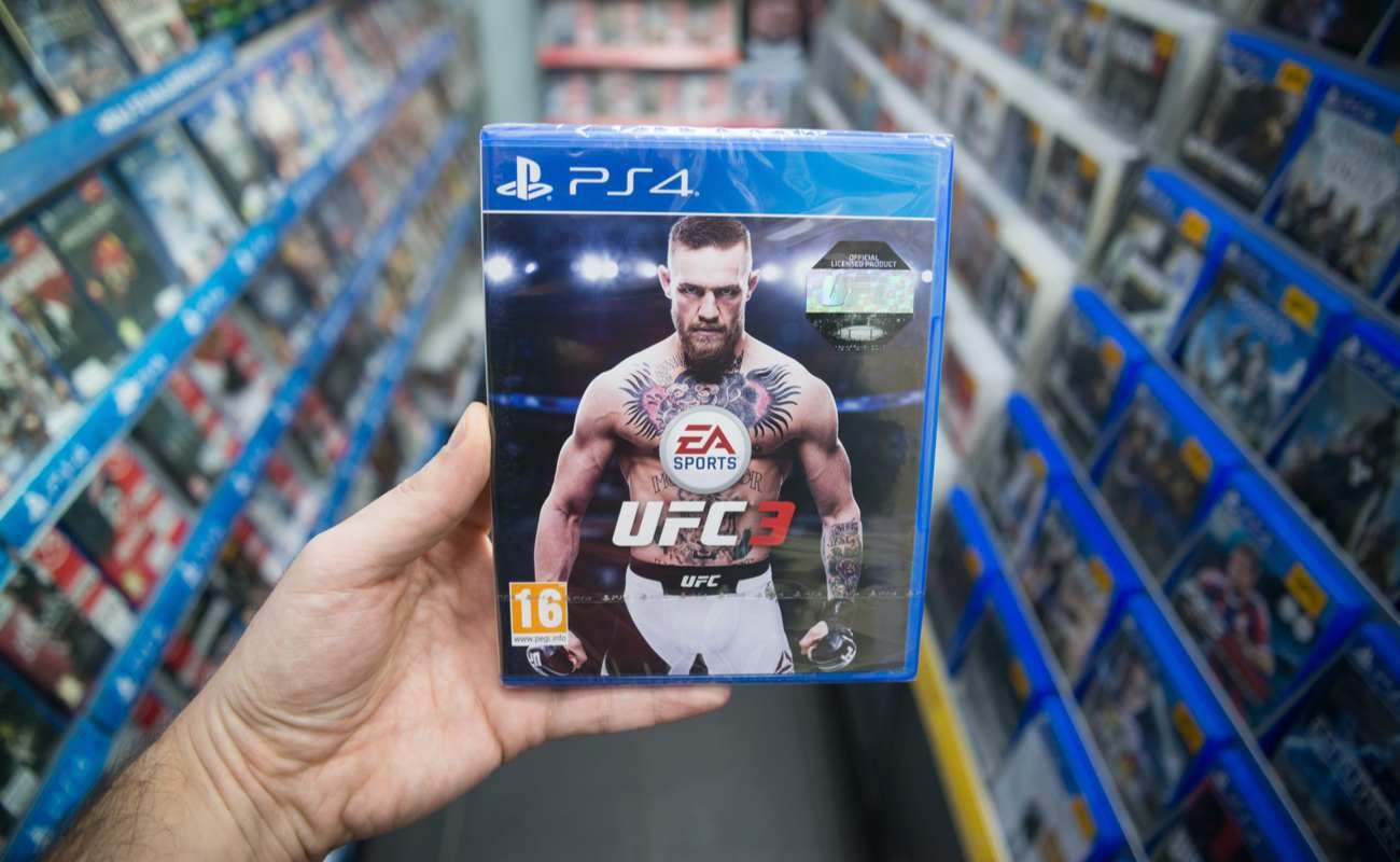 Man holding UFC 3 video game on Sony PlayStation 4 console